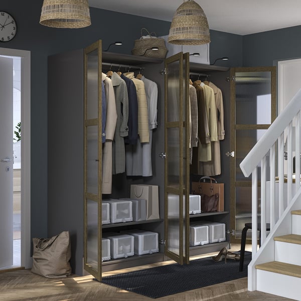 Modern closet with clothes, storage bins, and handbags. Integrated lighting and adjustable hinges.