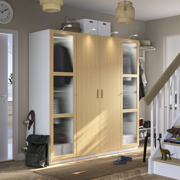 Large wooden wardrobe with glass doors, surrounded by toys, in a cosy room.