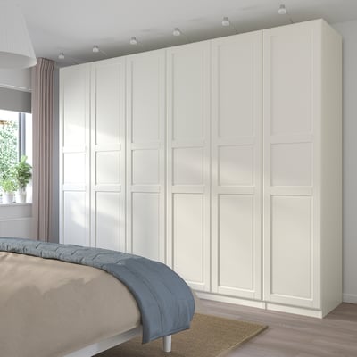 Modern, white PAX wardrobe, tall, fit clothes, add storage, sleek design, beside bed.