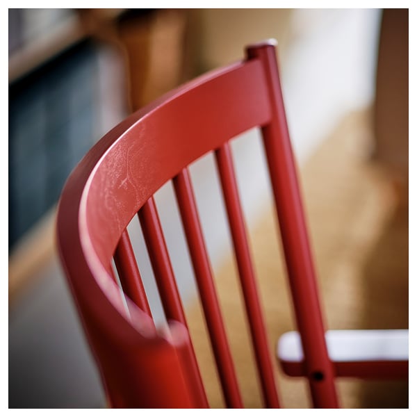 Red chair backrest, sleek design; smooth wooden finish suggests high-quality craftsmanship.