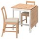Wooden drop-leaf table with two chairs. Natural wood top, white legs. Beige cushioned seats. Minimalist design.