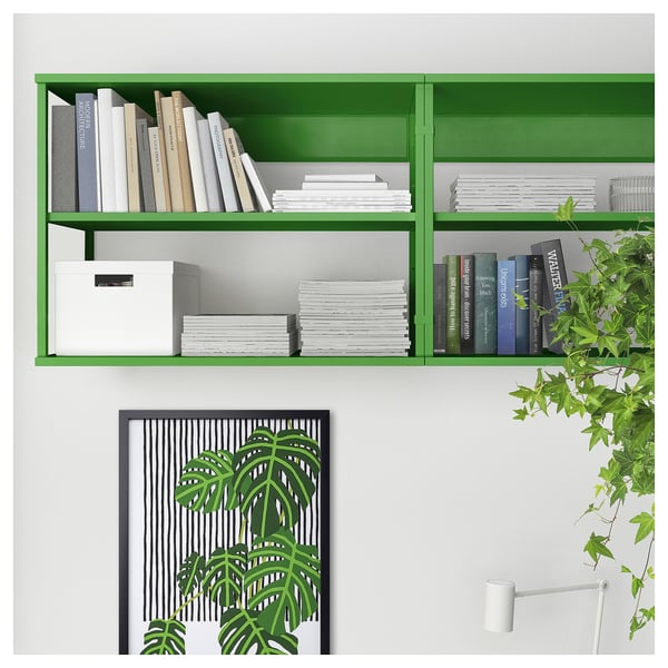 Green PLATSA storage shelf, holding books and files with a white box, mounted on a white wall.
