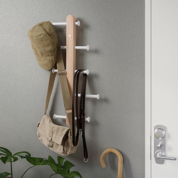 Wall-mounted storage rack with bags and a hat, organising entryway.