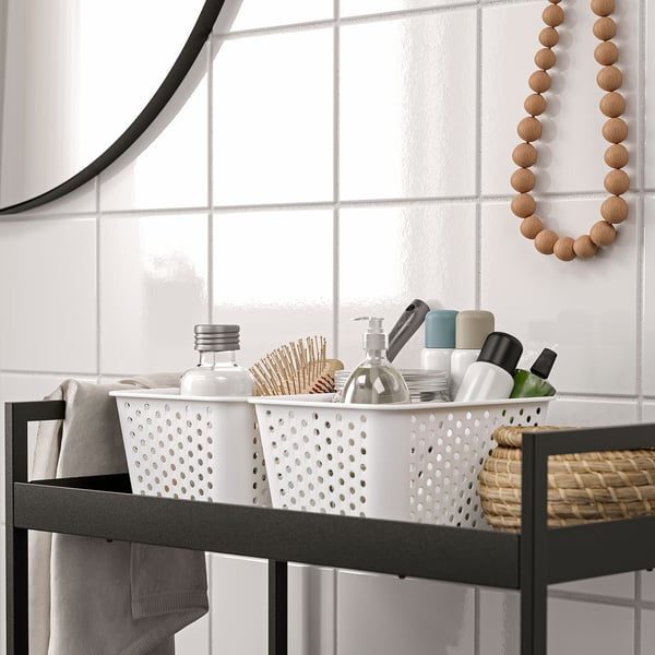 Bathroom storage basket organises toiletries and beauty products on shelves.
