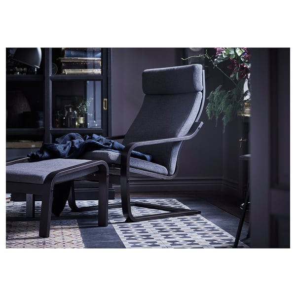 Modern dark grey reclining chair with footstool, stylish curved lines, comfy cushions.