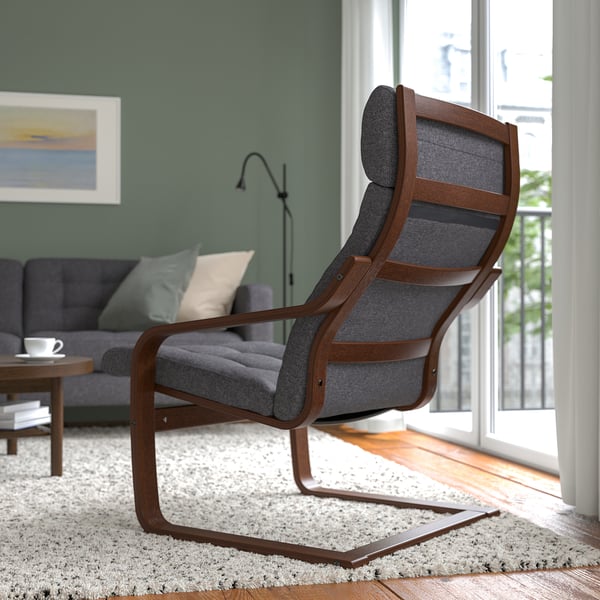 Grey cushioned POÄNG armchair with curved frame in living room.