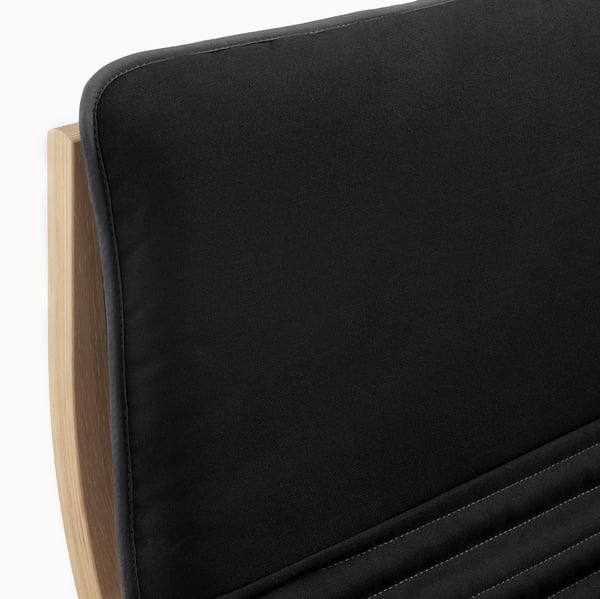 Black cushioned chair with wooden frame, showcasing high-quality materials and comfortable design.