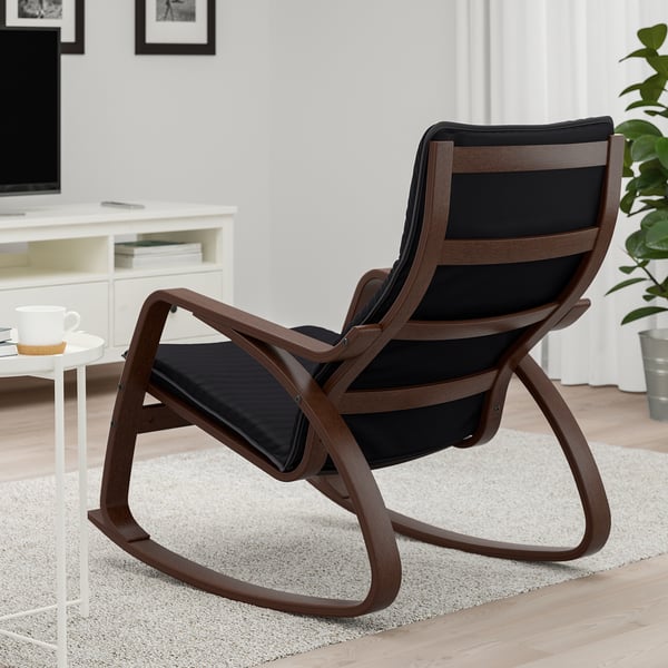 Black leather rocker chair with wooden frame in modern living room.