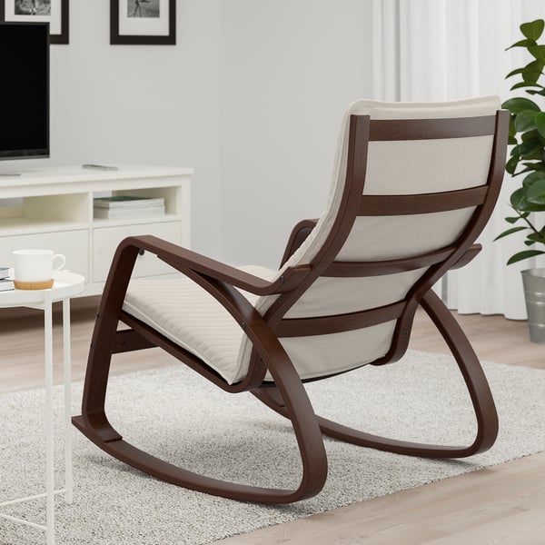 A comfortable rocking chair with a wooden frame and beige cushion is placed on a rug in a cosy living room.