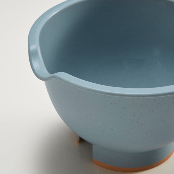 Light blue bowl with handle and spout, sits steady on wide base.