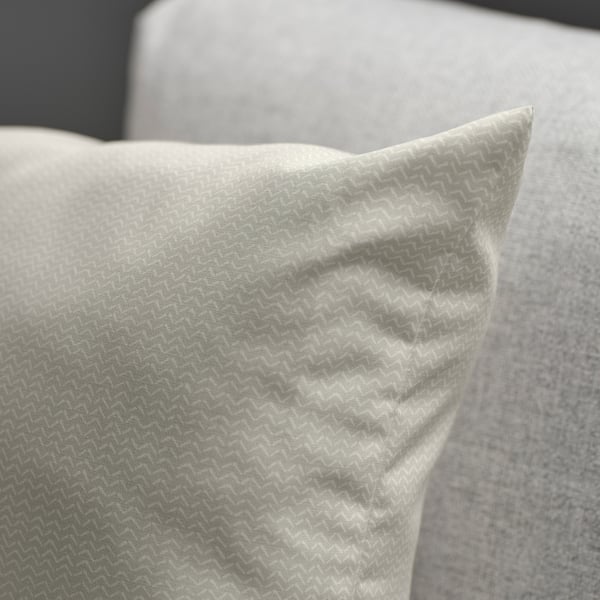 Close-up of a cosy, light beige cushion with subtle pattern and soft sheen, designed for comfort and style.
