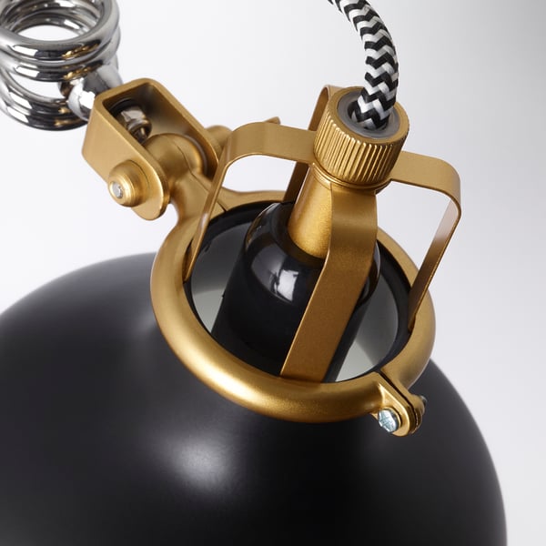 Modern adjustable clamp lamp with sleek black shade and gold accents. A classic patterned cord and durable metal construction.