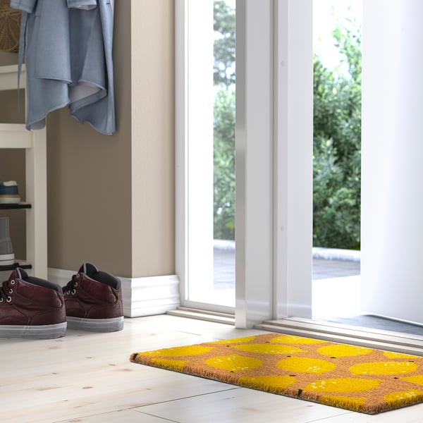 Yellow lemon-patterned doormat welcomes guests at entrance.