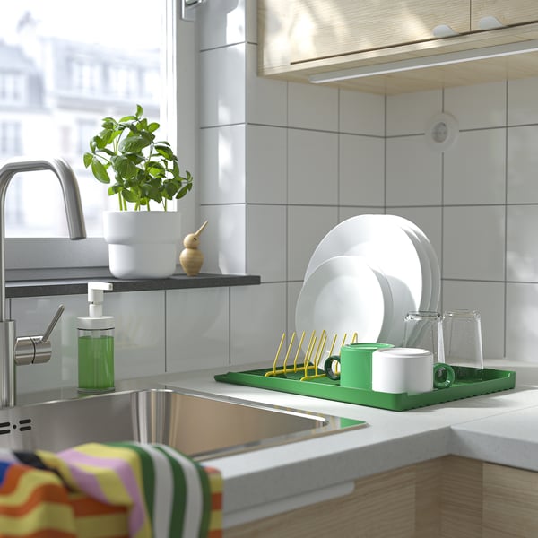 Modern kitchen sink with RINNIG dish drainer and supplies.