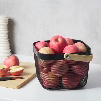 Mesh basket holds apples, ventilates for freshness, sits on countertop.
