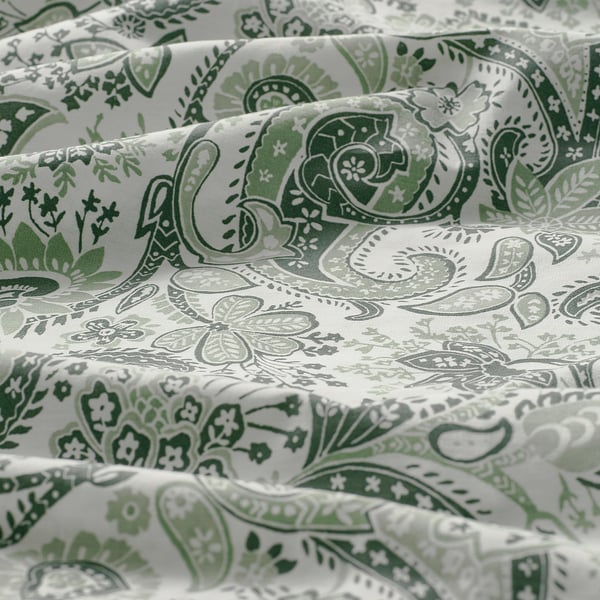 Luxurious paisley fabric close-up. Green patterns on soft, sheened cotton-viscose blend.