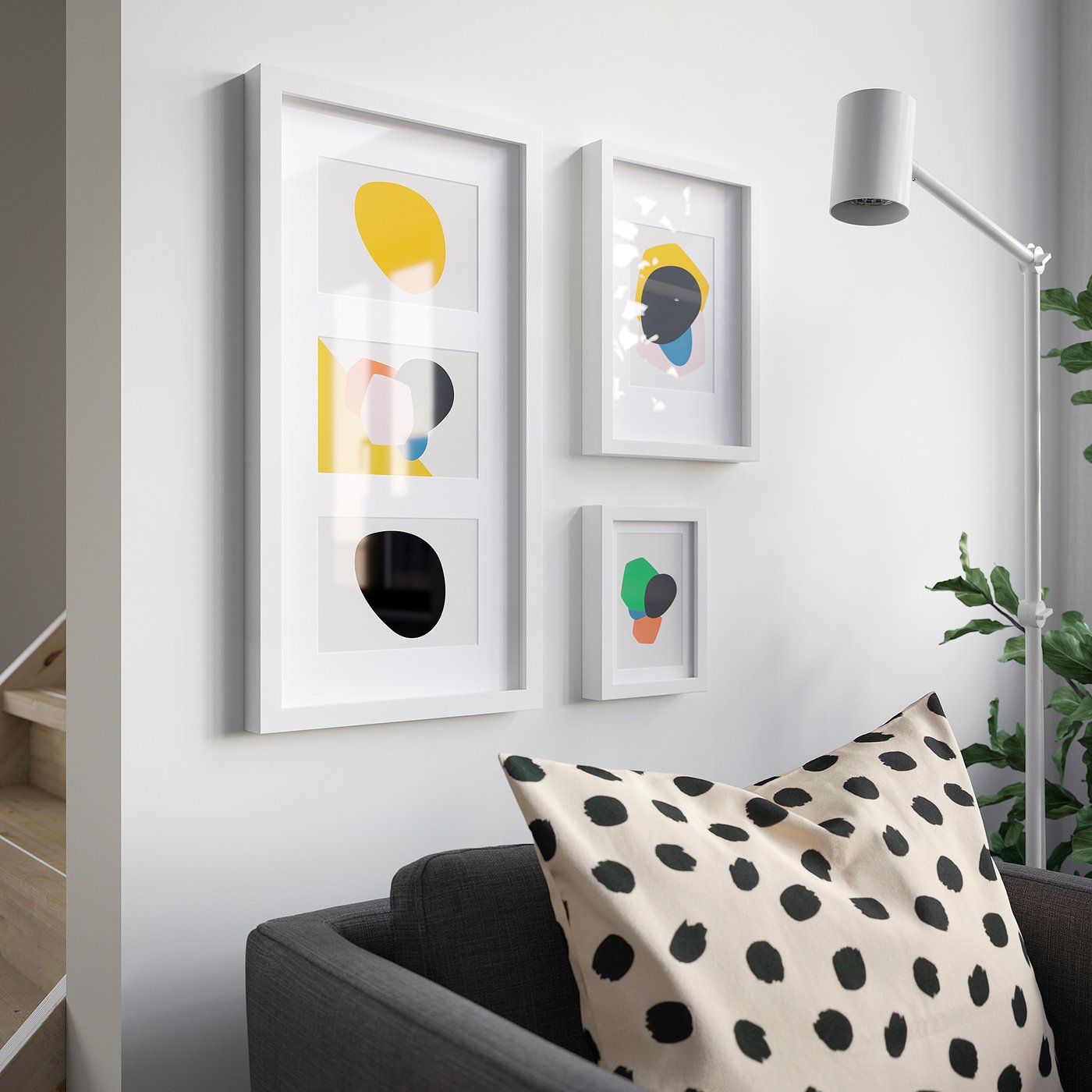 Modern room with white walls, colourful paintings, black armchair, cream pillow, tall lamp.