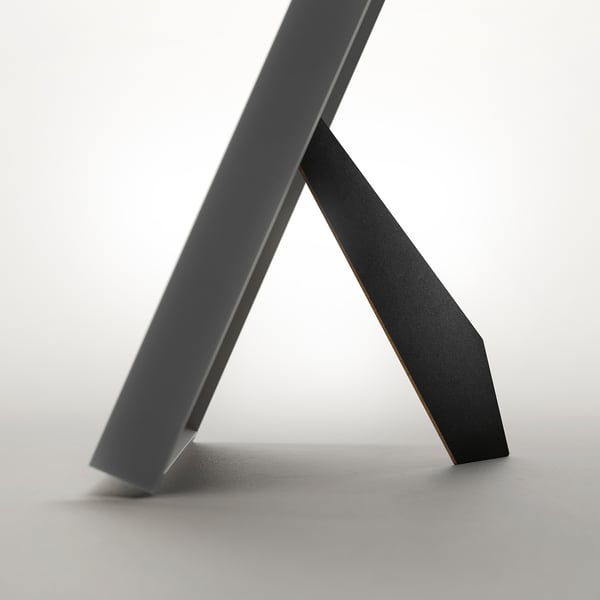 Modern picture frame with angled stand, can display photo in front or back, and can be hung or stood both ways.