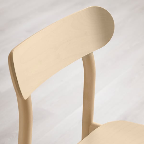 Close-up of a wooden chairs backrest and side frame. Smooth finish showcasing wood grain, indicating quality craftsmanship.