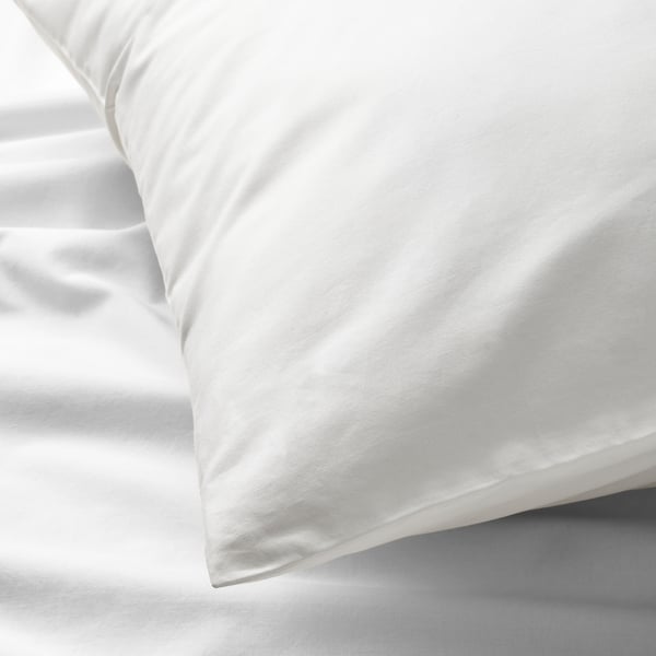 Clean, crisp white sheets and pillowcases, neatly arranged, showcasing high-quality cotton percale.