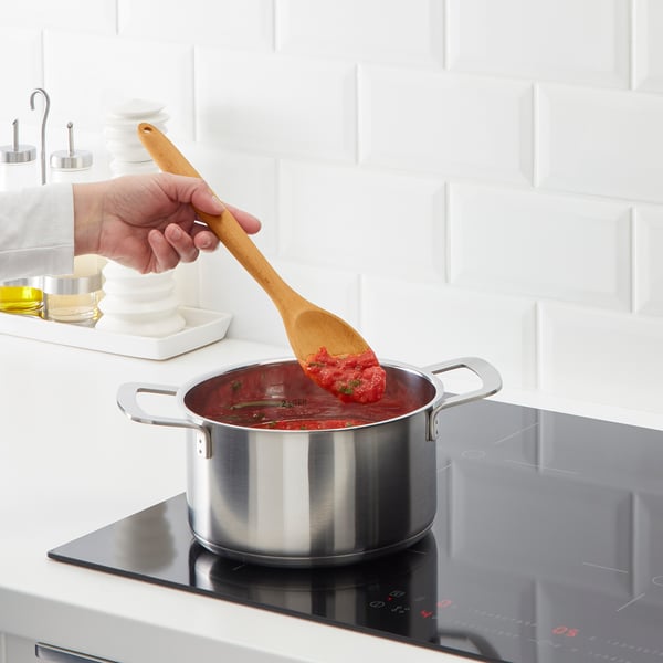 Cooking red sauce on black stove