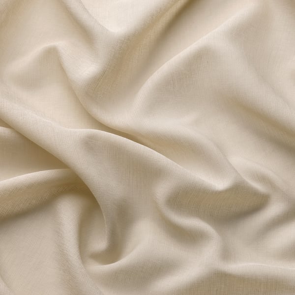 Soft, beige sheer curtain folds elegantly; made from recycled polyester, offering privacy while allowing gentle light.