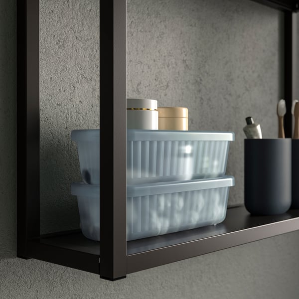 A bathroom shelf with a clear plastic storage box, holding small containers, demonstrating organisation and easy visibility of items.