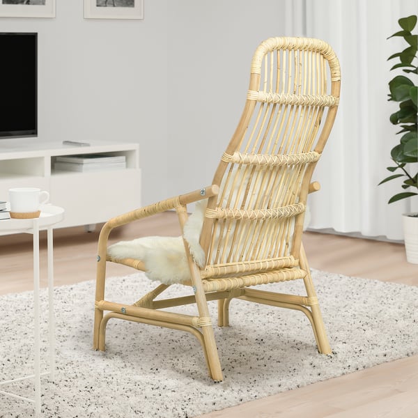 Natural rattan armchair with cream fur cushion; stylish, relaxed setting with modern decor.