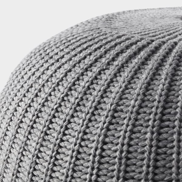 Close-up of knitted pouffes textured surface, showcasing intricate stitching and soft fabric.