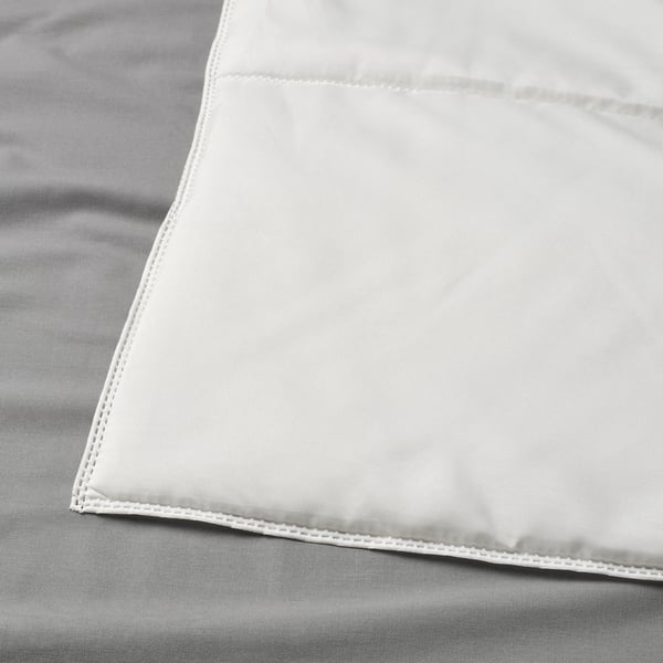 Close-up of a thin, light, white duvet. Visible stitching along edges, showcasing quality craftsmanship.