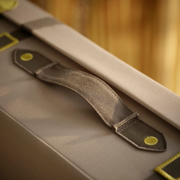 Close-up of durable, recycled polyester bag strap with secure yellow buckle.