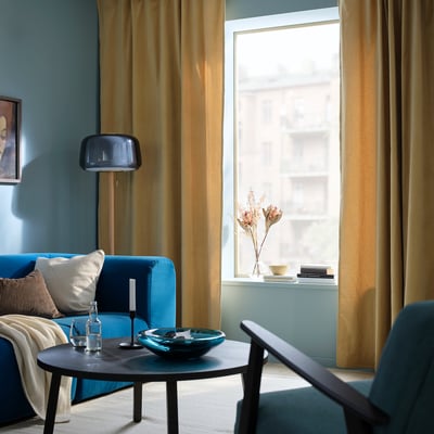 SANELA curtains in beige-yellow perfectly frame large window, enhancing rooms cosy, luxurious feel.