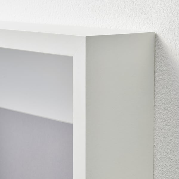 Close-up of white SANNAHED picture frame on wall, showing clear white finish and sturdy construction.
