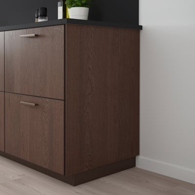 SINARP brown oak kitchen cabinet with sleek handles against white wall.