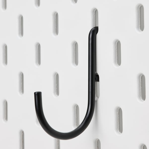 Black metal hook firmly attached to a white pegboard, designed for wall organisation.