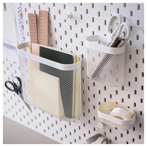 SKÅDIS white metal mesh organisers on pegboard. Holds stationery, scissors, and tape.