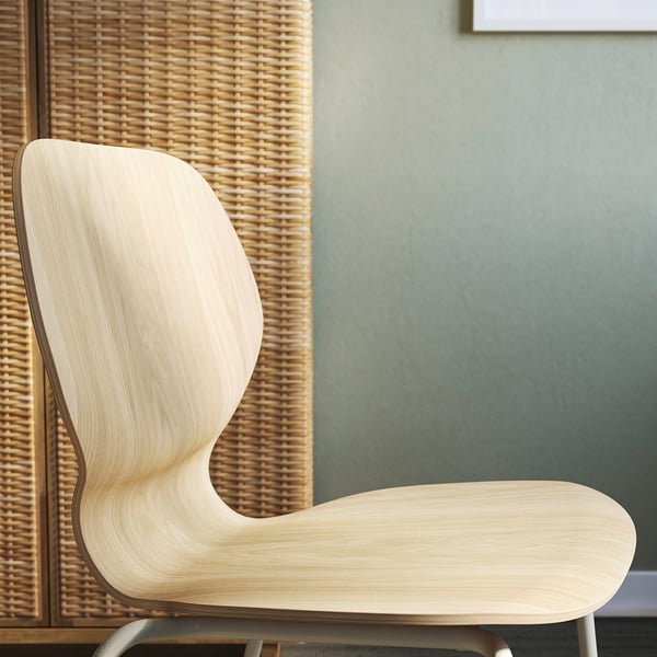 Light wood chair with smooth finish, leaning against woven division.