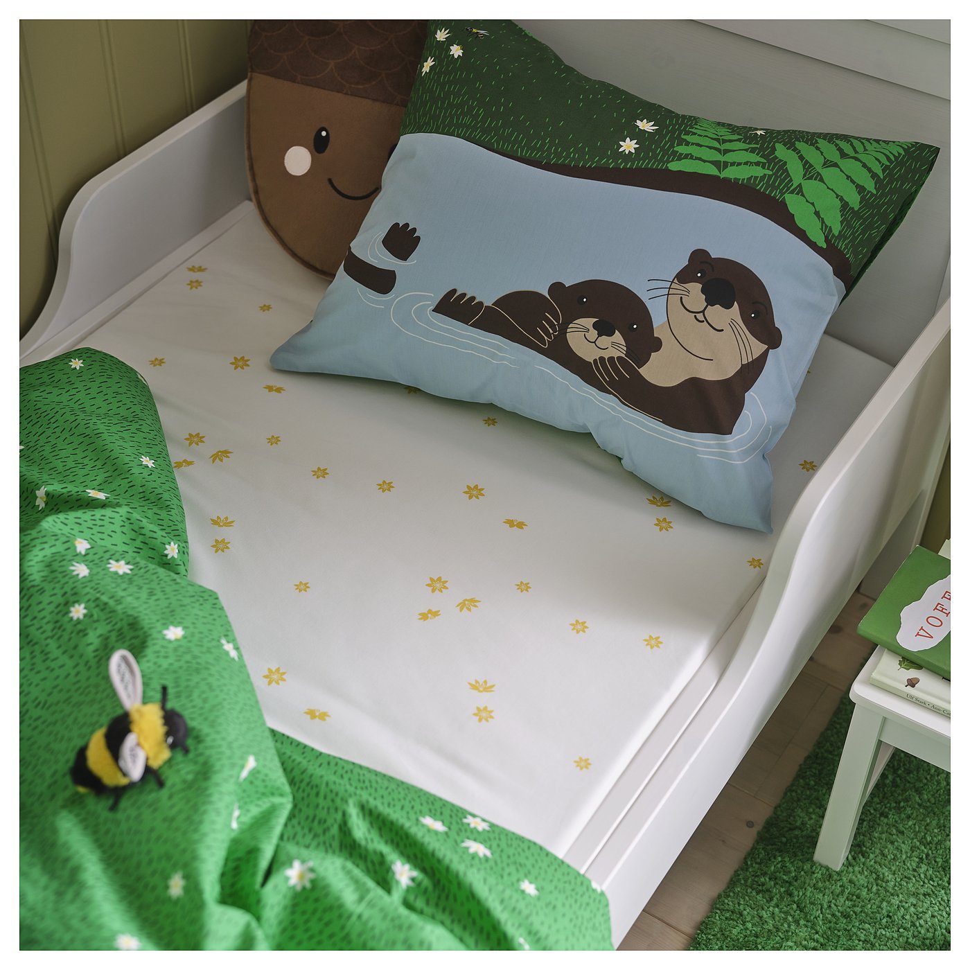 Blue bear bed with green blanket & stool, cuddly toy, tree print.