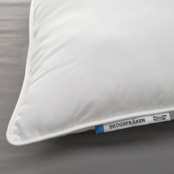 Close-up of a white SKOGSFRÄKEN pillow on a bed, showcasing its soft, textured fabric and supportive design.
