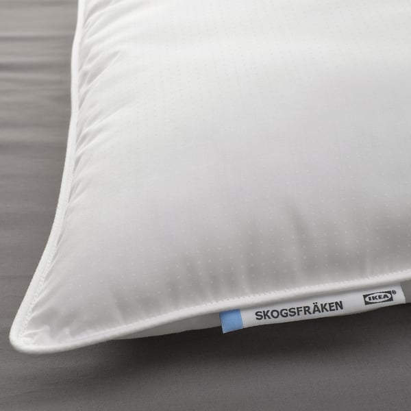 A white pillow from IKEAs SKOGSFRÄKEN line, displayed on a bed, showcasing its soft, supportive texture and quality materials.