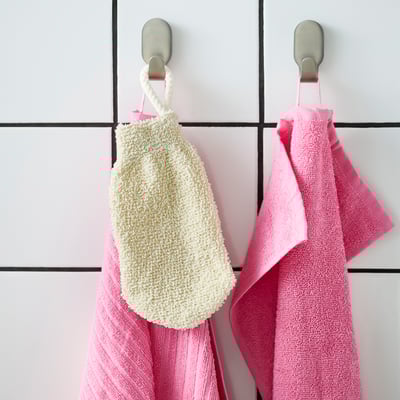 Hooks holding white scrub mitt & pink striped towels.