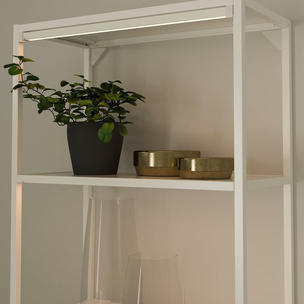 Shelf with plant, bowls, vases, and light.