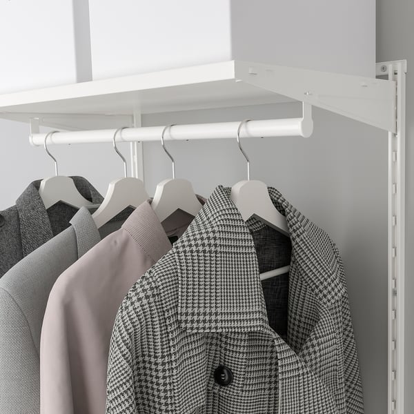 A white closet system with a shelf and hanging clothes on hangers below it.