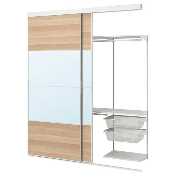 SKYTTA wardrobe system with white and wooden sliding door, metal hanging rods, shelves, and mesh baskets.