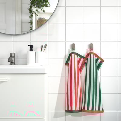 Bright red & green-striped SLÅNHÖSTMAL towels hang beside white sink and mirror.