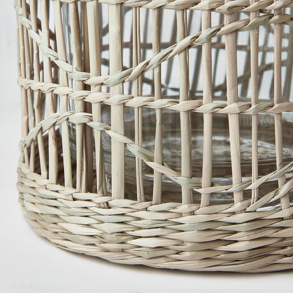 Crafted lantern with intricate wicker design, showcasing natural materials and refined weave pattern. Ideal for adding warmth and ambiance.