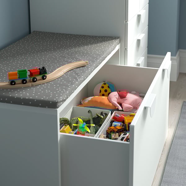 Open toy storage box under bench, showing toys inside.