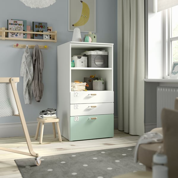 SMÅSTAD bookcase in nursery, white/green, drawers, decor, coat rack, stool, wood floors, window, rug.
