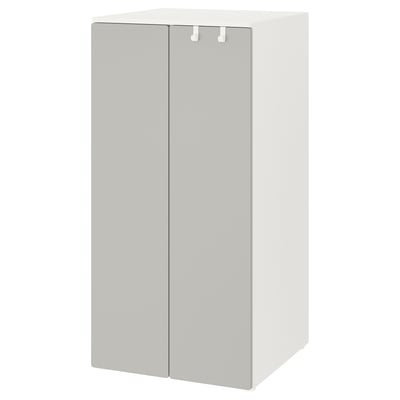 A white SMÅSTAD wardrobe, designed for children. Its square-shaped with two doors, soft-closing hinges, and adjustable feet for stability.