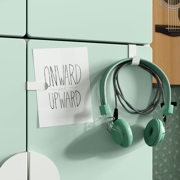 Mint-colored fridge with stuck note onward and upward and headphones, reflect youthful, motivational theme.